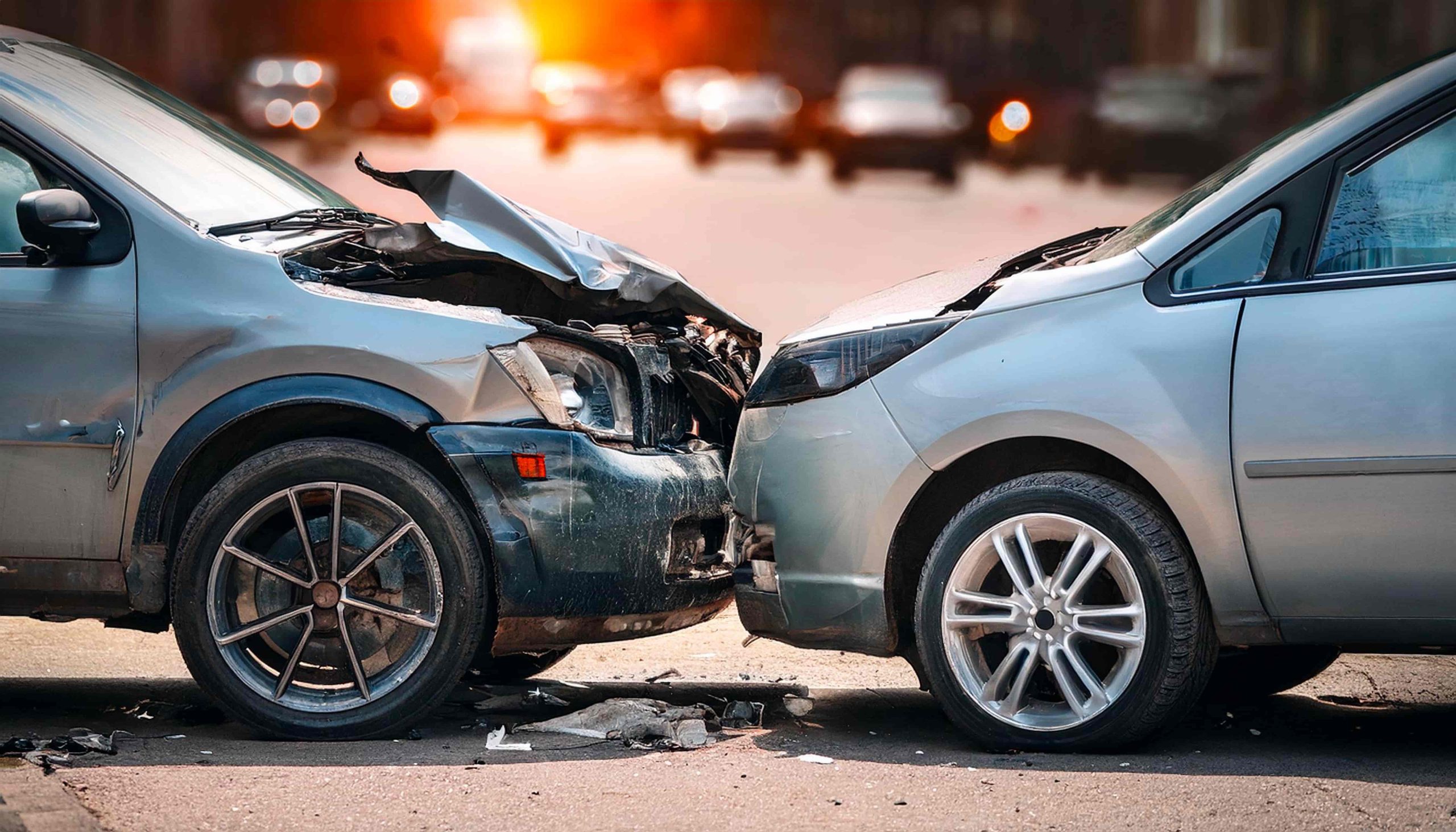 Head-on car accident with two damaged vehicles on city street